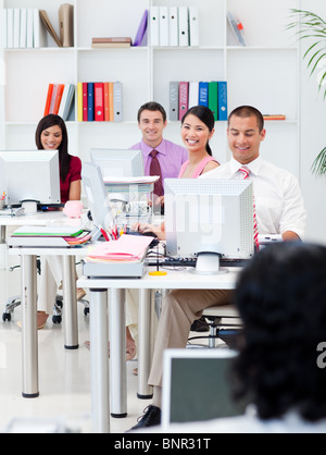 Smiling business people working at computers Stock Photo