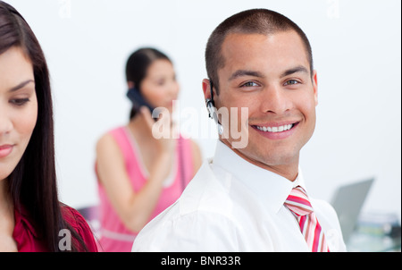 Portrait of a man with an hands-free set and his team Stock Photo