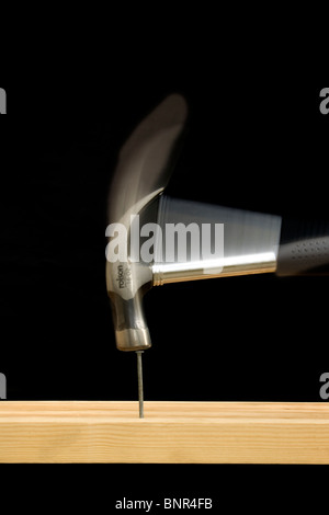 An 'action' shot of a claw hammer hitting a nail on the head Stock Photo