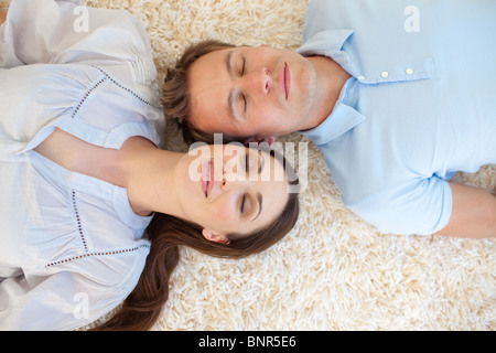 Affectionate couple lying on the floor Stock Photo