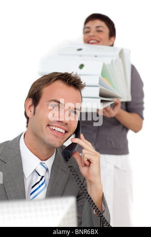 Businessman on phone with his colleague bringing a stack of folders Stock Photo