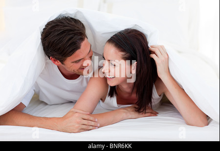 Couple talking together and lying on bed Stock Photo
