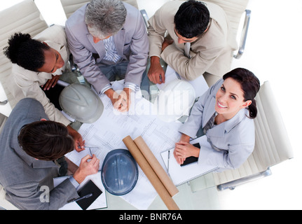 High angle of architects studying blueprints Stock Photo