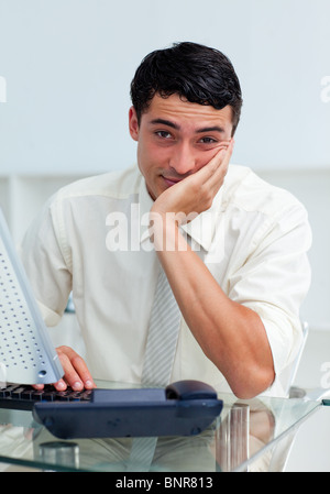 Bored young businessman at his desk Stock Photo