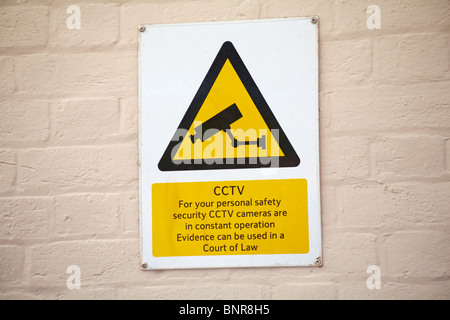 CCTV notice on buff coloured wall in UK Stock Photo