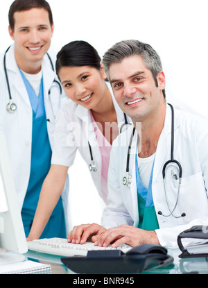 Smiling doctors and nurse working at computer Stock Photo