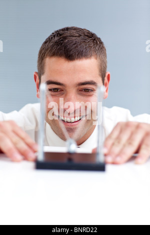 Businessman looking at kinetic balls Stock Photo