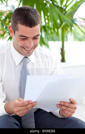 Businessman studying some documents on sofa Stock Photo