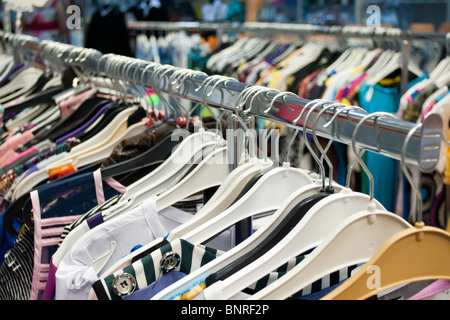 The clothes hangs on a hangers in a shop ready to sale. Fashion sale concept. Stock Photo