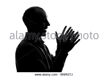 Silhouetted man clapping hands Stock Photo