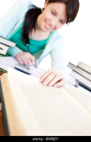 Cheerful student doing her homework on a desk Stock Photo