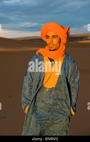 A Berber cameleer in the Sahara desert at Merzouga, Morocco at dawn Stock Photo