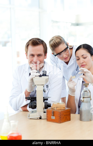 Scientists looking at a slide under a microscope Stock Photo