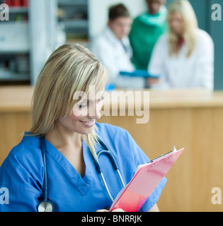 Portrait of a nice female surgeon with her team behind her Stock Photo