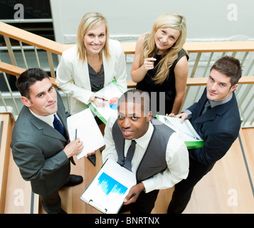 Business team working on stairs and smiling at the camera Stock Photo