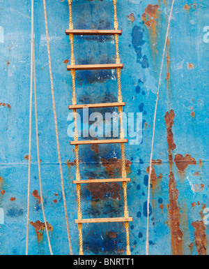 Rope ladder on side of rusting trawler Stock Photo