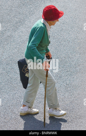 Elderly woman with walking sick crossing road - France. Stock Photo