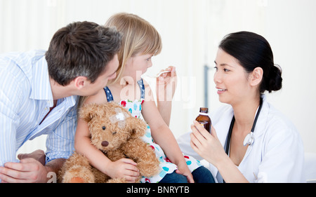 Professional female doctor giving syrup to a little girl Stock Photo