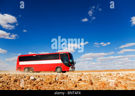 A bus drives along a dirt road in outback Queensland, near Birdsville, Queensland, AUSTRALIA. Stock Photo