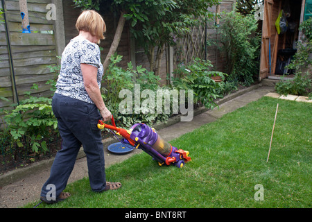 Vacuuming the grass lawn with a Dyson vacuum cleaner Stock Photo