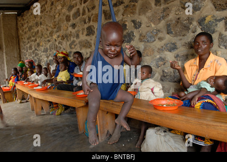 A malnourished child is weighed at a Therapeutic Feeding Center for IDP Congolese in North Kivu province DR Congo Africa Stock Photo