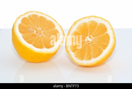 This fresh juicy lemon is cut in half and is shot on a light background with a soft reflection shadow. A classic citrus stock. Stock Photo