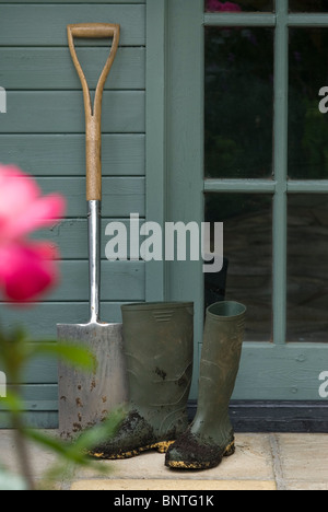 Boots and spade outside a garden guilding Stock Photo