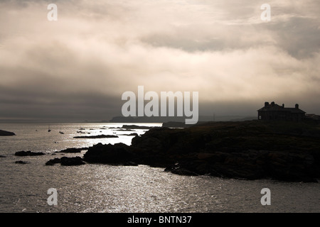 House silhouetted against the sky, overlooking the coast, Trearddur Bay, Anglesey, North Wales, UK Stock Photo