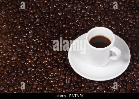 Freshly brewed espresso on coffee bean background Stock Photo