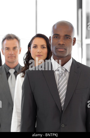 Serious ethnic business leader in front of team Stock Photo