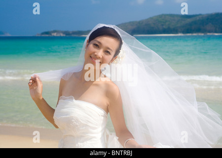 Bride in a veil on the beach Stock Photo