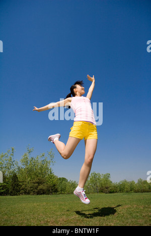 Young woman jumping in the air at the park Stock Photo
