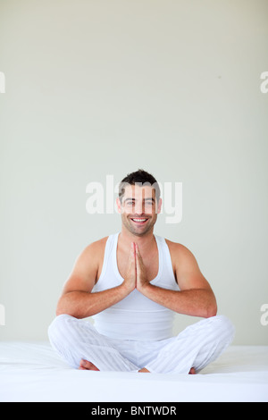 Young man doing yoga in his bedroom Stock Photo