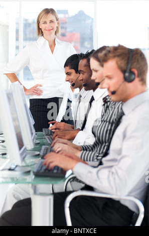 Female leader managing her concentrated team in a call center Stock Photo