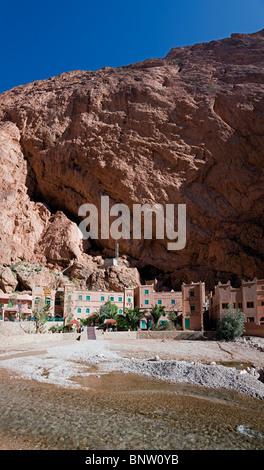 Todra Gorge and Hotel Yasmina below over-hanging cliffs, near Dades Valley, Morocco Stock Photo