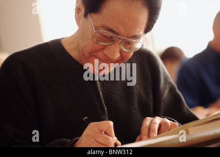 Senior student writing in notebook Stock Photo