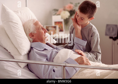 Grandson visiting Grandfather in hospital Stock Photo