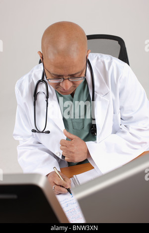 Doctor working at his desk Stock Photo