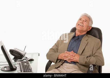 Businessman relaxing at his desk Stock Photo