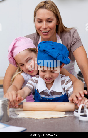 Mother and children baking cookies in the kitchen Stock Photo