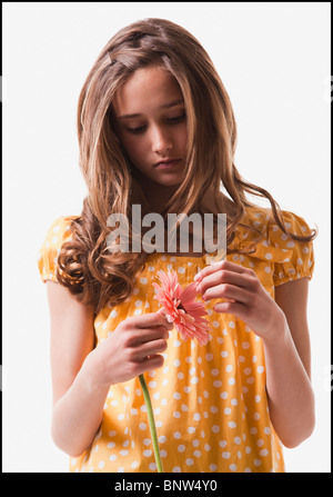 Teenage girl picking petals off of a flower Stock Photo