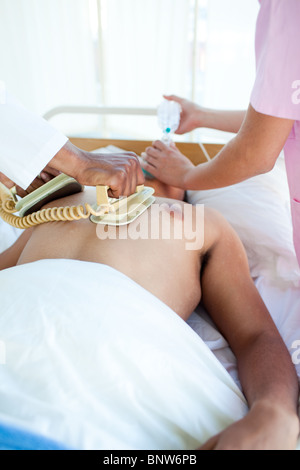 A doctor performing a CPR with a defibrillator on a patient Stock Photo