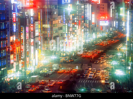 Neon lights and busy streets in Shinjuku District of Tokyo at night Stock Photo