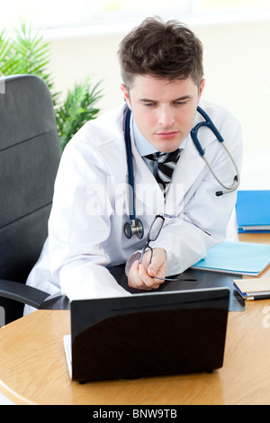 Confident male doctor using a laptop Stock Photo