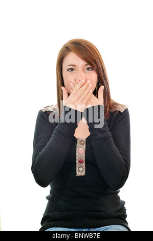 A pretty teenage girl covers her mouth in surprise. Portrait, cutout, white background. Conceptual. USA Stock Photo