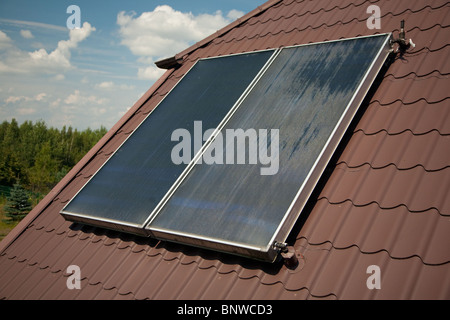 Flat-plate solar collector on roof in summer Stock Photo