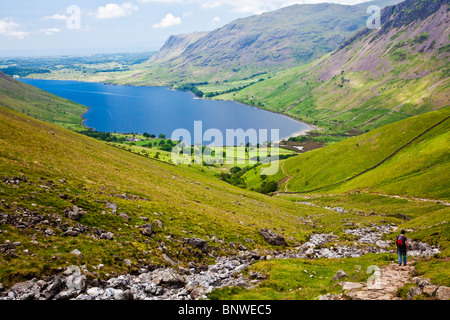 View over Wast Water from the Wasdale Head route up to Scafell Pike, Lake District, Cumbria, England, UK with walker descending. Stock Photo