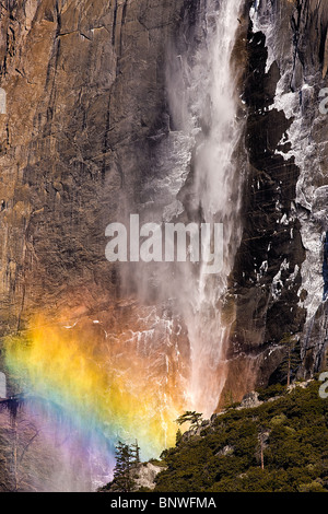 Early morning sun creates a rainbow in the mist of upper Yosemite Falls, Yosemite National Park, California, USA. Stock Photo