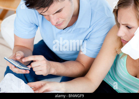 Cute couple using a remote in the living-room Stock Photo