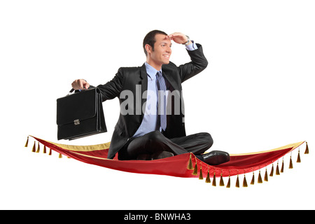 A businessman holding a suitcase while flying on a magic carpet Stock Photo